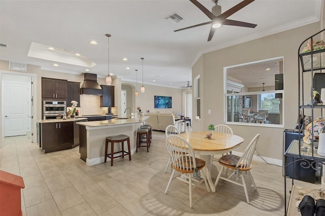 dining room featuring ceiling fan, ornamental molding, and visible vents