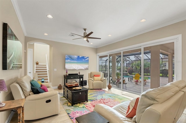 living room with arched walkways, recessed lighting, visible vents, a sunroom, and crown molding