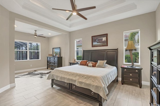 bedroom featuring a tray ceiling, crown molding, and baseboards