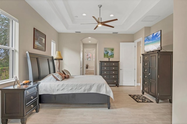 bedroom with arched walkways, a tray ceiling, visible vents, and recessed lighting