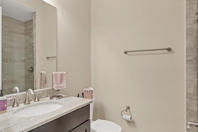 bathroom with a stall shower, vanity, and toilet