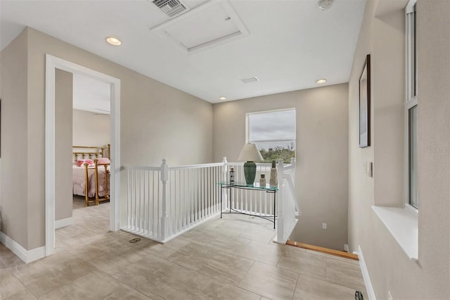 corridor with recessed lighting, visible vents, attic access, an upstairs landing, and baseboards