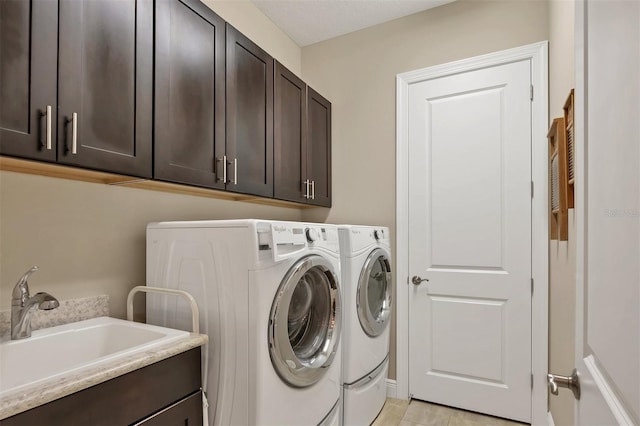 washroom with a sink, washing machine and dryer, and cabinet space