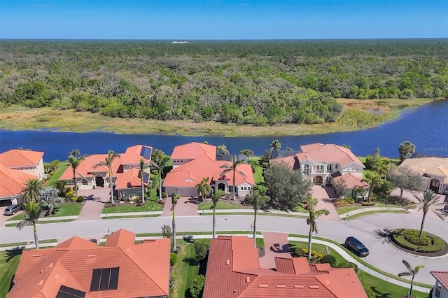 drone / aerial view with a water view, a wooded view, and a residential view