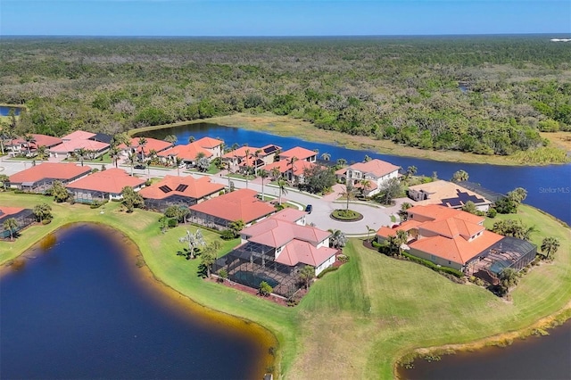 drone / aerial view featuring a residential view, a water view, and a forest view