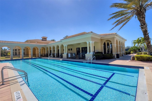 pool with fence and a patio