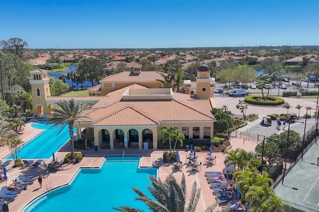 community pool with a patio and fence