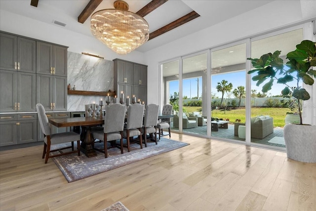 dining room with visible vents, beamed ceiling, light wood finished floors, and an inviting chandelier