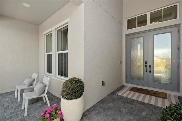 doorway to property featuring stucco siding and french doors