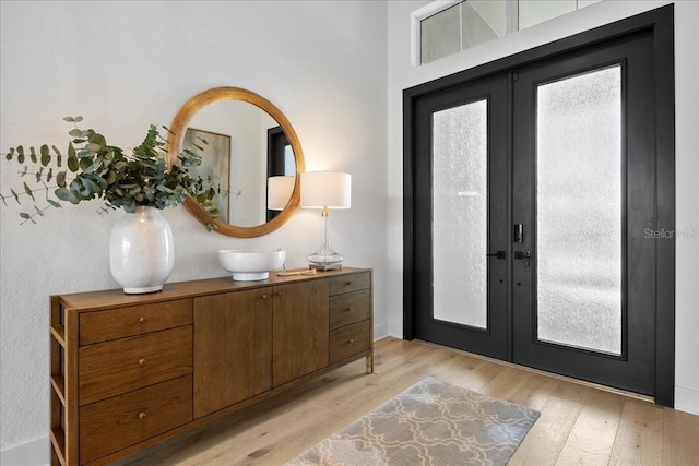 entrance foyer featuring light wood finished floors and french doors