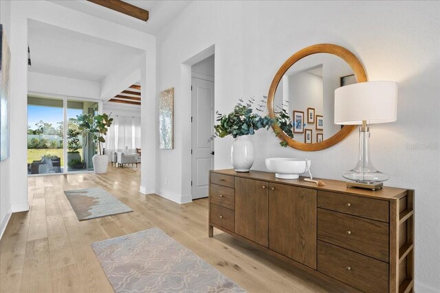 hallway featuring light wood-type flooring and baseboards