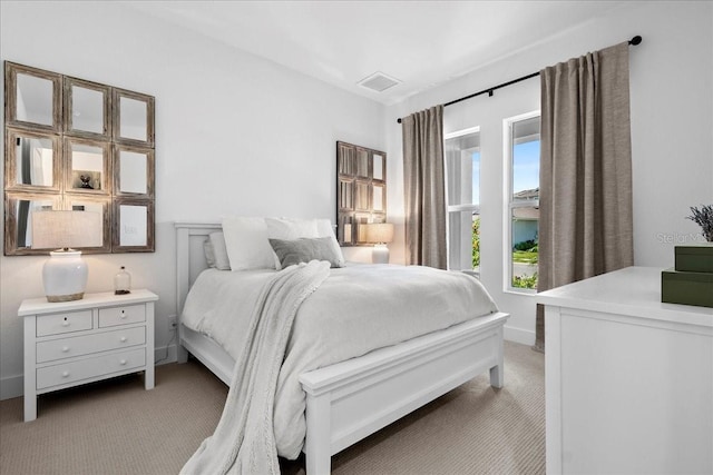 bedroom with light colored carpet, visible vents, and baseboards