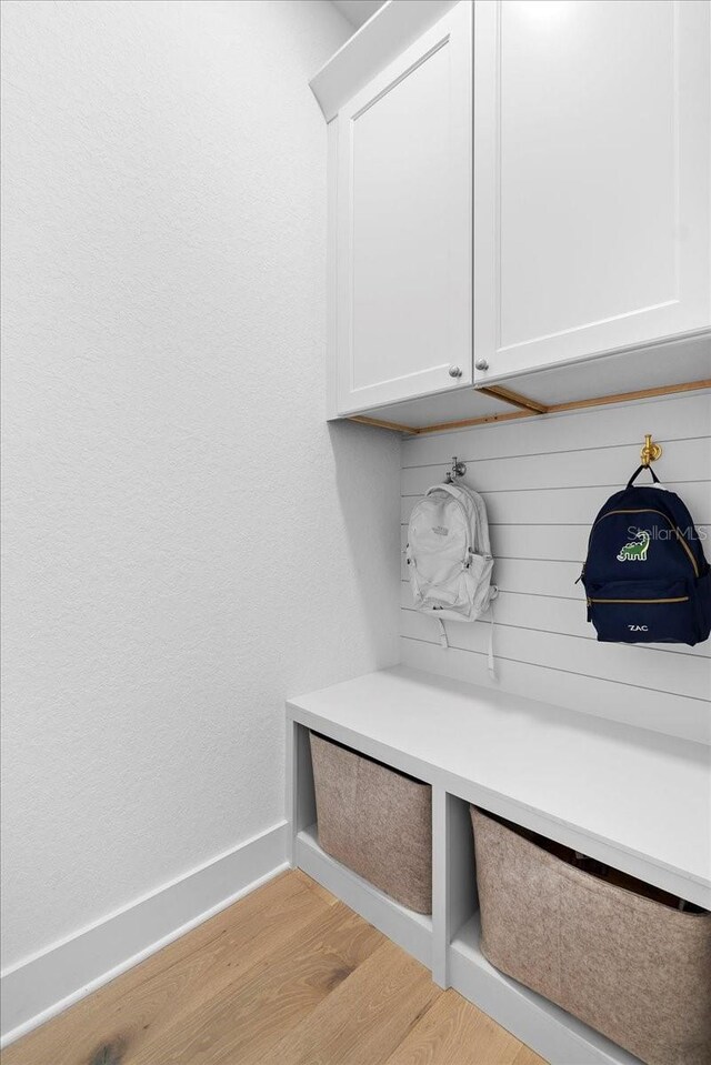 mudroom with light wood-style flooring and baseboards