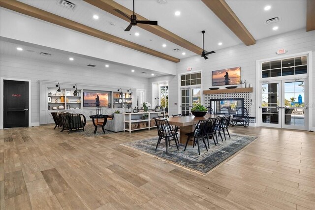 dining area with french doors, beamed ceiling, wood finished floors, and visible vents