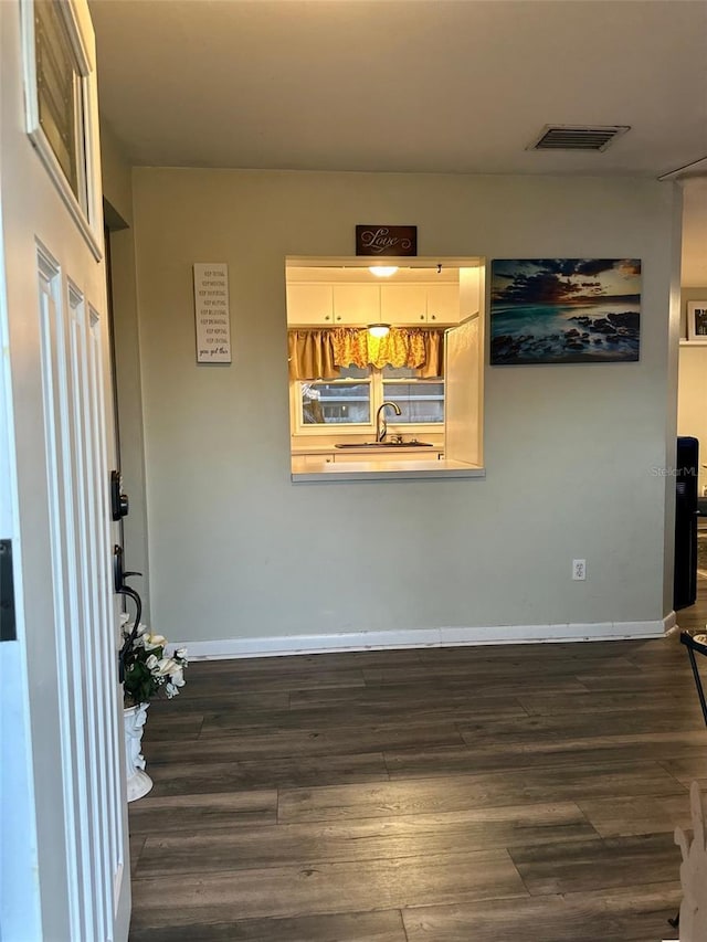 interior space with dark wood-style floors, baseboards, and visible vents