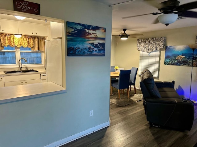 interior space featuring ceiling fan, dark wood-style flooring, and baseboards