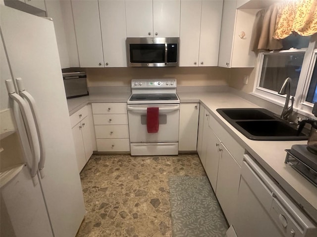 kitchen with light countertops, white appliances, white cabinets, and a sink