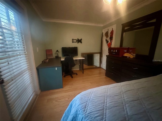 bedroom with light wood-style floors and crown molding