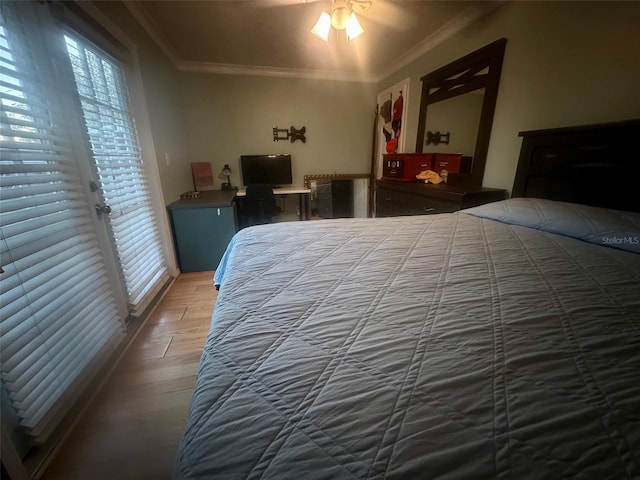 bedroom featuring access to outside, crown molding, and wood finished floors