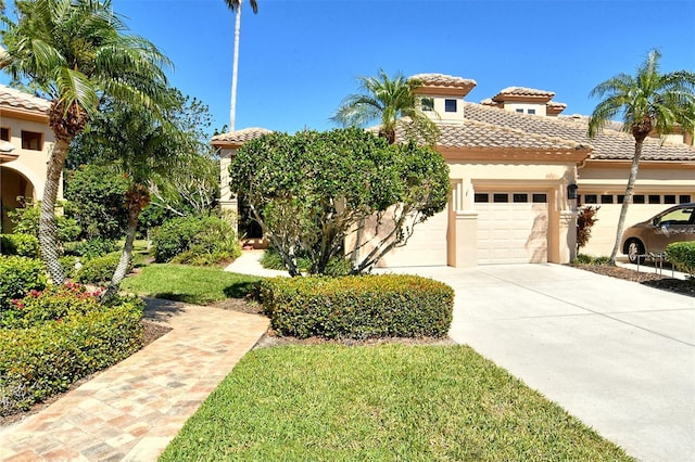 view of front of home with a tile roof, stucco siding, driveway, and an attached garage