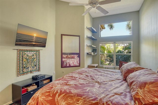 bedroom with a high ceiling and ceiling fan