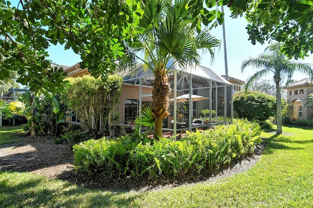 exterior space with a yard, a lanai, and stucco siding