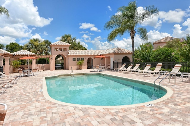 community pool with fence and a patio area