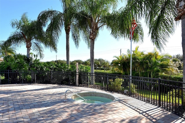 view of pool featuring a hot tub and fence