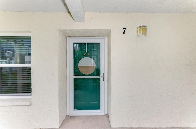 entrance to property featuring stucco siding