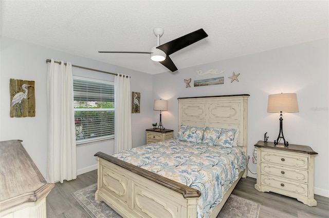 bedroom with baseboards, a textured ceiling, a ceiling fan, and wood finished floors