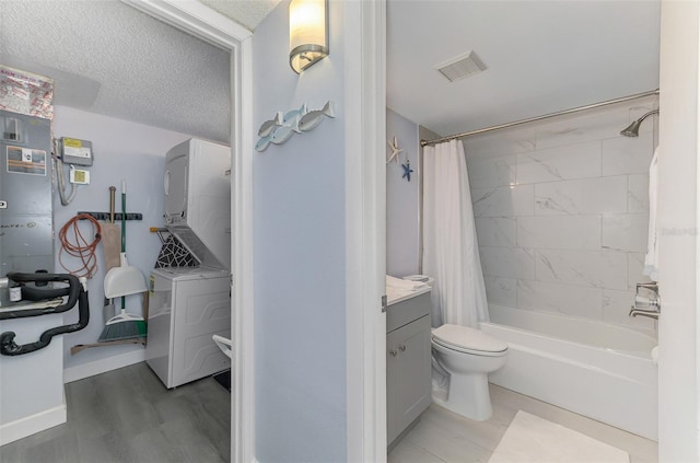 full bathroom featuring shower / tub combo, visible vents, a textured ceiling, vanity, and stacked washing maching and dryer