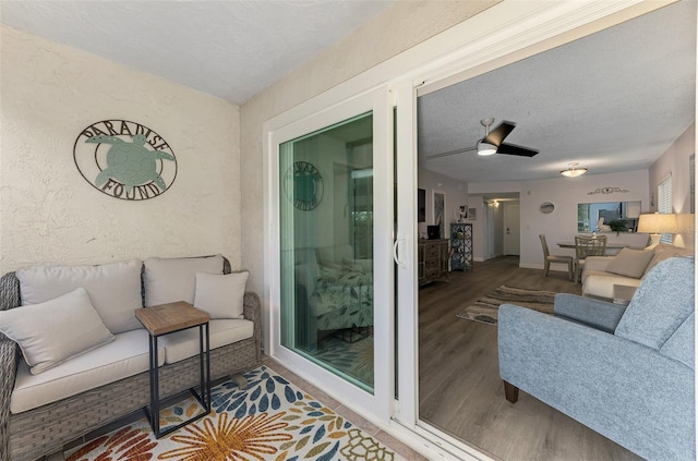 interior space featuring a textured wall, a textured ceiling, and wood finished floors