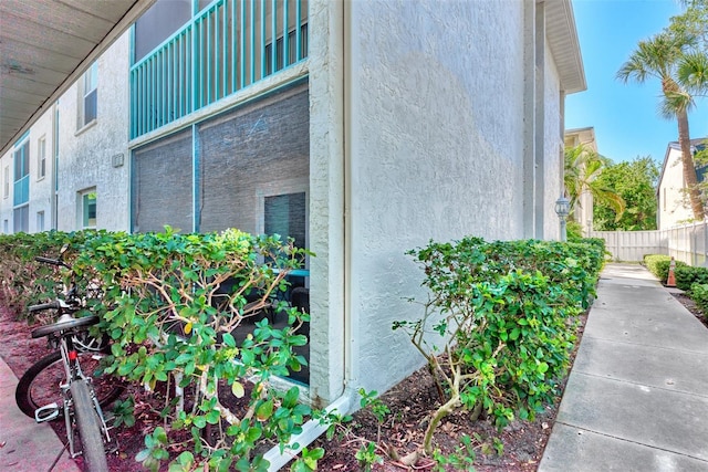 view of home's exterior with fence and stucco siding