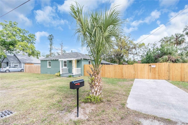 bungalow-style house with a front lawn, fence, and stucco siding