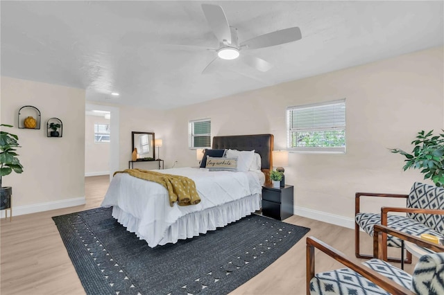 bedroom with light wood-style flooring, baseboards, and ceiling fan