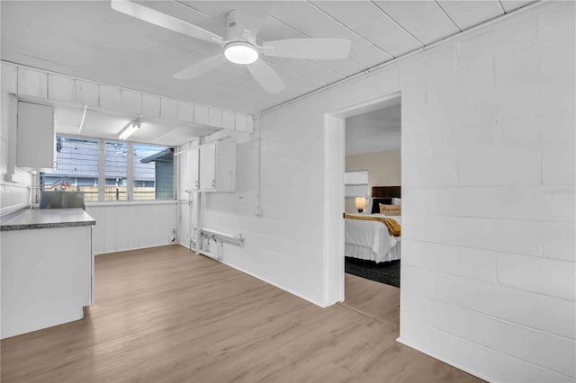 kitchen with white cabinets, ceiling fan, and light wood finished floors