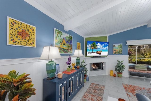 tiled living room with lofted ceiling with beams, wainscoting, wooden ceiling, and a glass covered fireplace