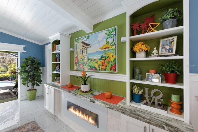 interior space with vaulted ceiling with beams, wood ceiling, a fireplace, and crown molding