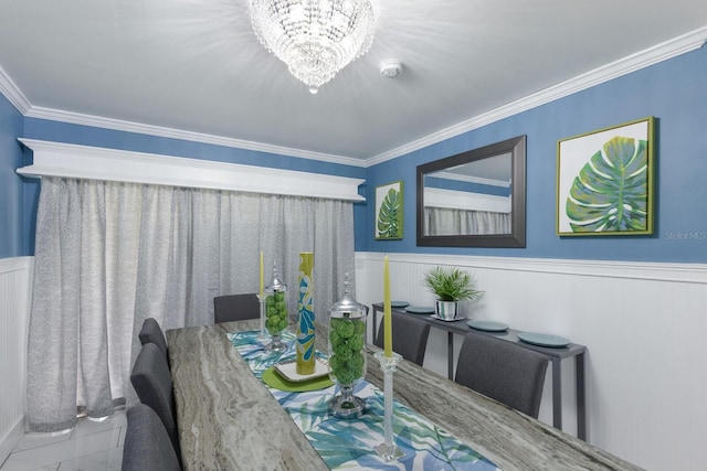 dining room with crown molding, a notable chandelier, and wainscoting