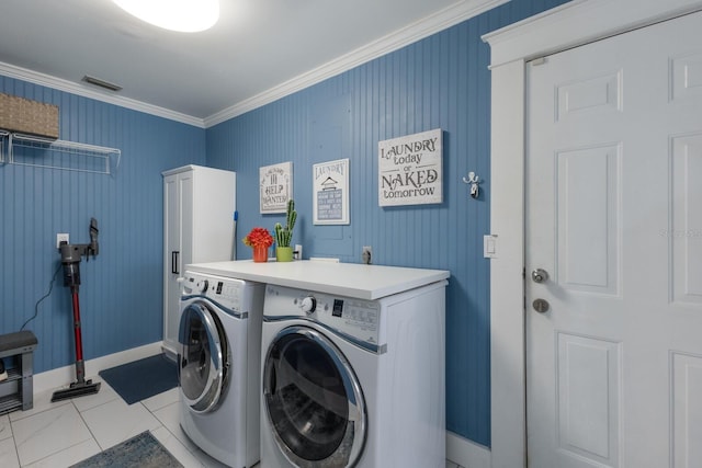 clothes washing area with visible vents, baseboards, ornamental molding, tile patterned floors, and washing machine and dryer