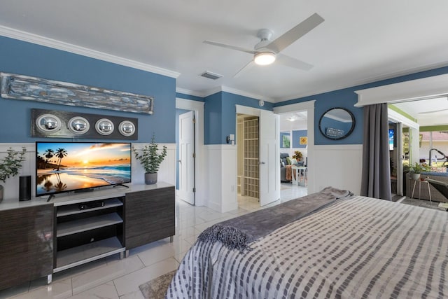 bedroom featuring ceiling fan, a wainscoted wall, visible vents, ornamental molding, and multiple windows