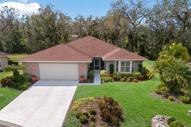 view of front of house with concrete driveway, a front lawn, and stucco siding