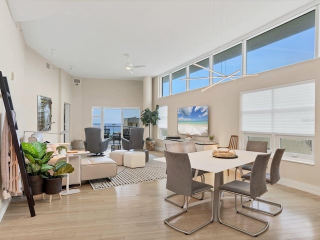 6512 Midnight Pass Rd Unit 504, Sarasota, FL 34242 - dining room featuring light wood-type flooring and a towering ceiling