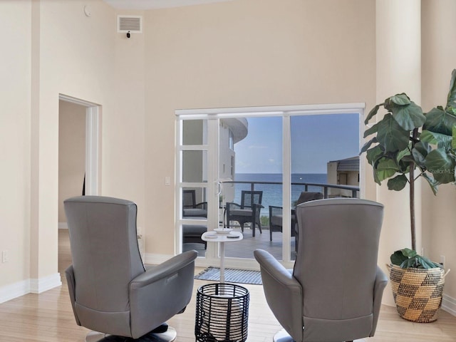 6512 Midnight Pass Rd Unit 504, Sarasota, FL 34242 - living area with light wood-style floors, a water view, and a towering ceiling