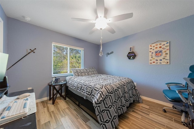 bedroom with ceiling fan, baseboards, and wood finished floors