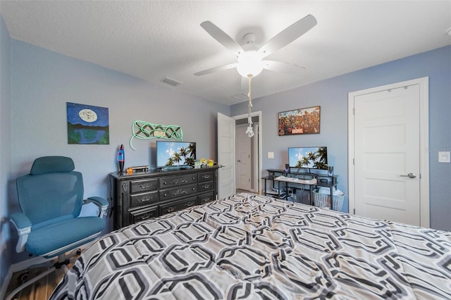 bedroom with visible vents, a textured ceiling, and a ceiling fan