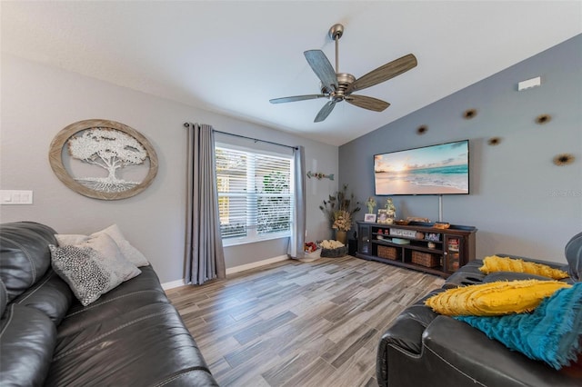 living area featuring a ceiling fan, lofted ceiling, baseboards, and light wood-type flooring