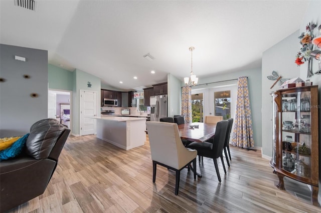 dining space featuring visible vents, light wood-style flooring, french doors, and lofted ceiling