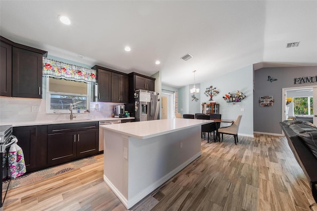 kitchen featuring visible vents, a sink, stainless steel appliances, light countertops, and lofted ceiling