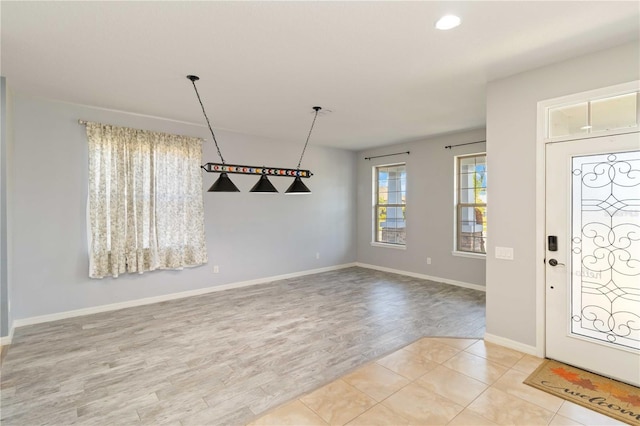 entrance foyer featuring baseboards and wood finished floors